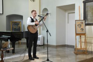 Josza Ćwik grający na gitarze i śpiewający