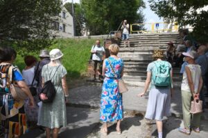 uczestnicy spaceru historycznego słuchający przewodnika