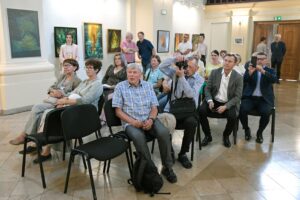 zwiedzający wystawę Żółte w zielonym słuchający wysąpienia wprowadzającego w wystawę