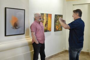 zwiedzający wystawę Żółte w zielonym robią zdjęcia na tle ekspozycji