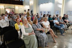 Publicznosć siedząca na krzesłach w kaplicy