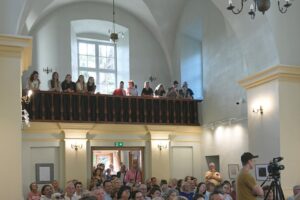 Publiczność stojąca na chórze w kaplicy