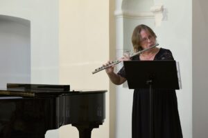 Dyrygentka chóru Cantate Deo gra na flecie poprzecznym